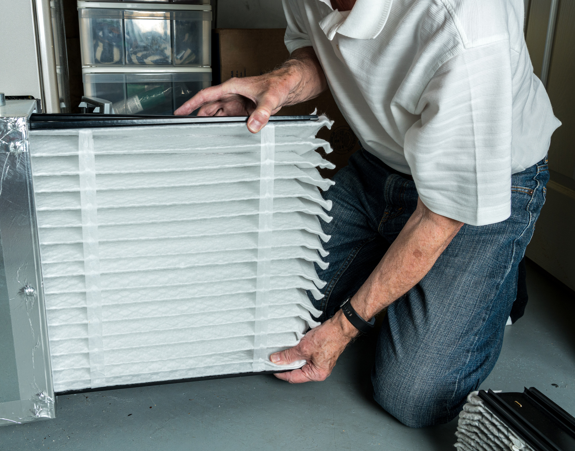 Man replacing furnace filter in home